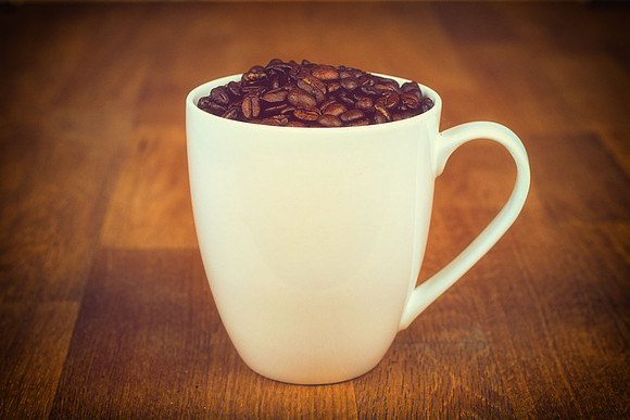 A coffee mug full of coffee beans by HabilePhotography